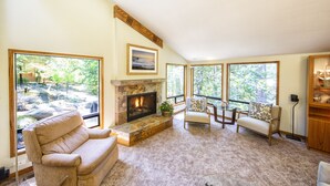 A cozy living room with a fireplace, large windows, and comfortable seating. - Wine Country Redwood Estate in the Heart of Wine Country (Santa Rosa)
