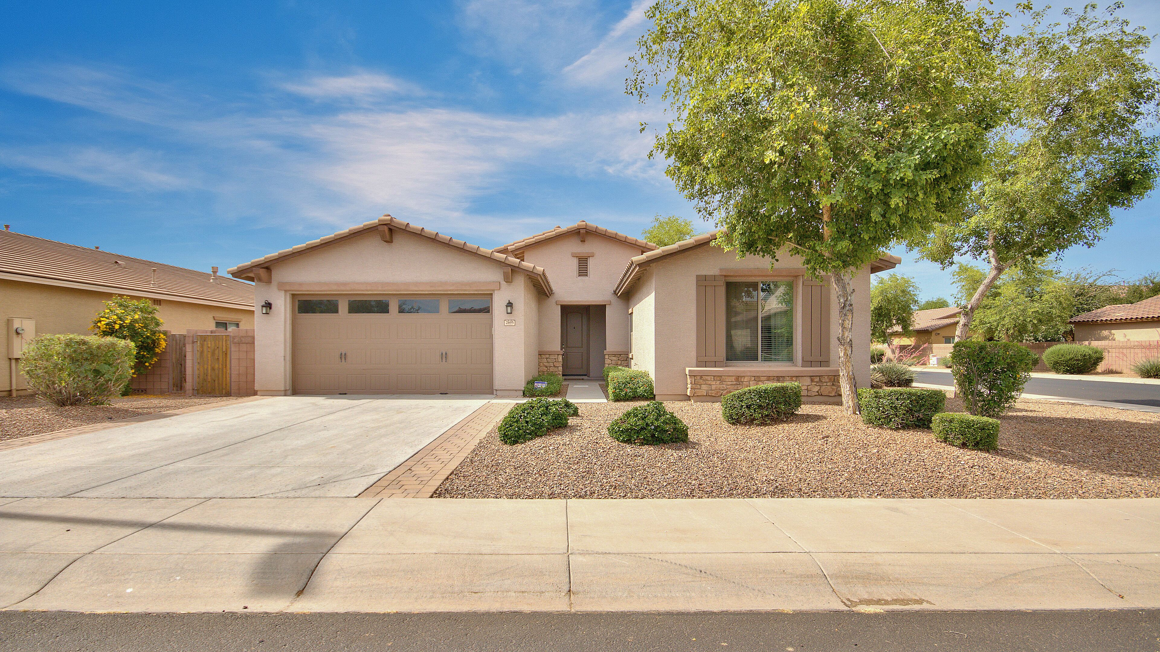 A two-story house with a garage, a front door, and a small front yard with landscaping.