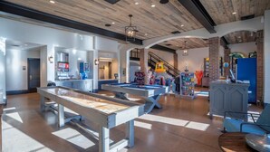 A spacious indoor area with pool tables, a bar area, and a staircase leading to an upper level. - Arcadia 30 | PAC-MAN * Asteroids Arcade * Games * Balcony Views * Resort Ameniti (Santa Clara)