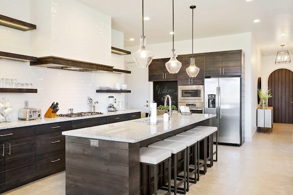 A modern kitchen with a large island, stainless steel appliances, and pendant lighting. - Arcadia 30 | PAC-MAN * Asteroids Arcade * Games * Balcony Views * Resort Ameniti (Santa Clara)
