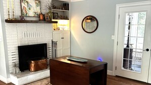 A living room with a fireplace, a coffee table, a rug, and a door with a view. - Home with lots of space for everyone on a quiet street in 5 points with pool! (Athens)