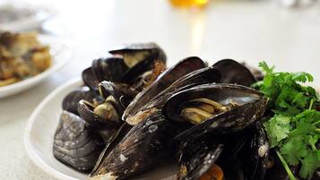 Un plato de mejillones con guarnición de perejil.