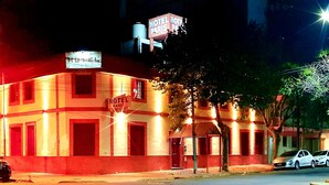 A building with a sign indicating it is a hotel. - Hotel Paris (General San Martin)