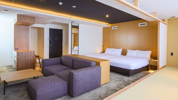 A modern hotel room with a bed, a seating area, and a desk. - Hotel Muso (Kyoto)