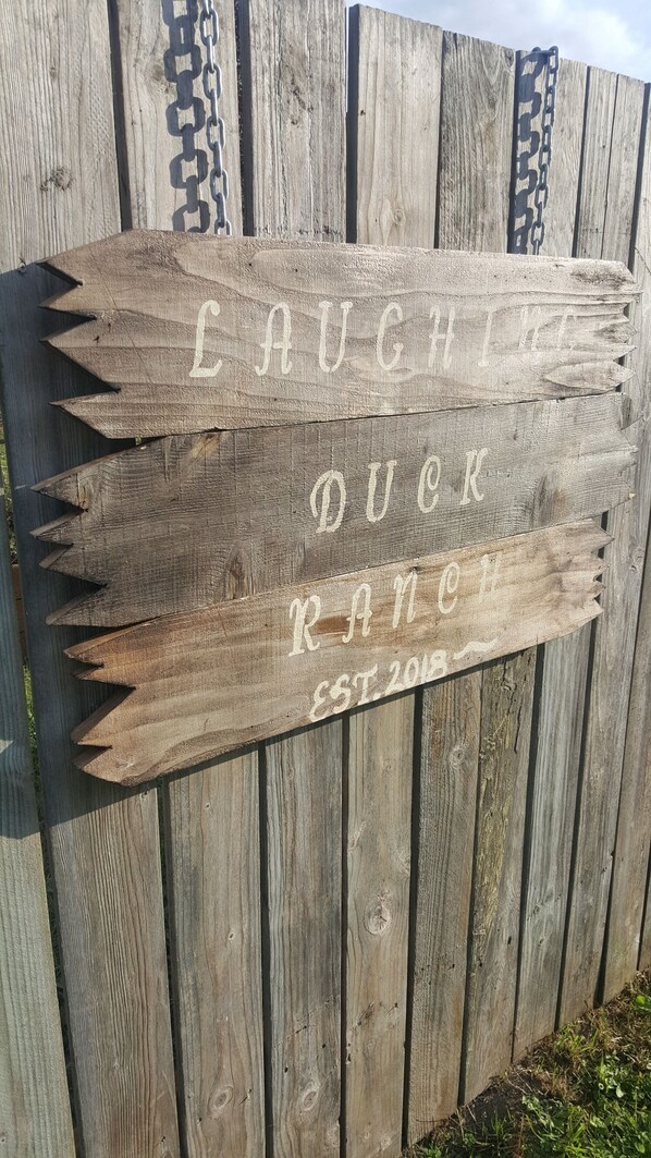 Ein hölzernes Schild mit der Aufschrift 'LAUGHIN' DUCK RANCH EST. 2018'.