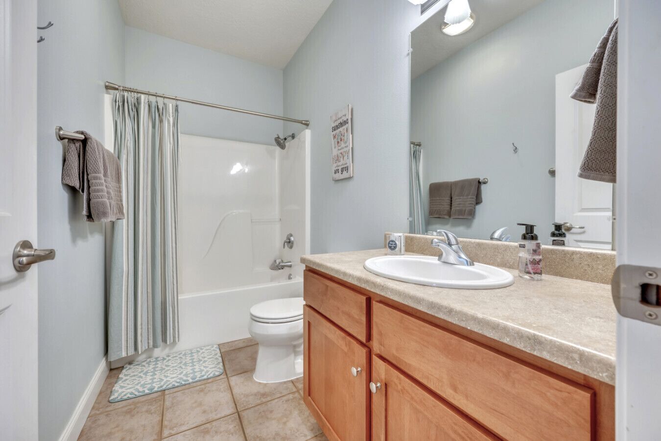 Un bagno con doccia, toilette e lavabo con specchio.
