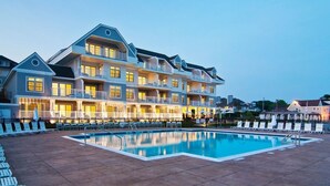 A large hotel with multiple balconies and a swimming pool.