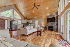 Relax in this inviting living area with a high ceiling, comfortable sofa, and stone fireplace.