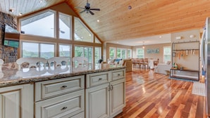 A spacious kitchen with a large island, wooden ceiling, and large windows offering views of the outdoors. - Waterfront, 2025 Tram, 2023 Dock, Sleeps 14, 3BR, 3.5 Bath, Wifi @ House & Dock (Jacksboro)
