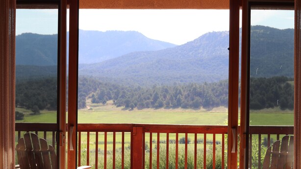 A wooden deck with a view of a mountainous landscape.
