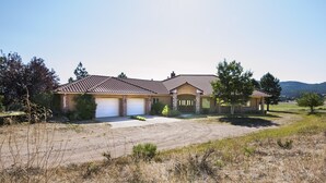 A two-story house with a tiled roof, a garage, and a driveway.