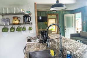 Enjoy cooking in this well-equipped kitchen with a sink, faucet, and ample storage.