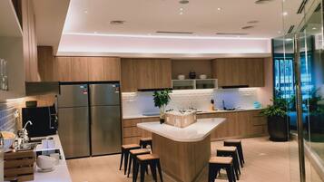 Una cocina moderna con armarios de madera, electrodomésticos de acero inoxidable y una isla central con taburetes.