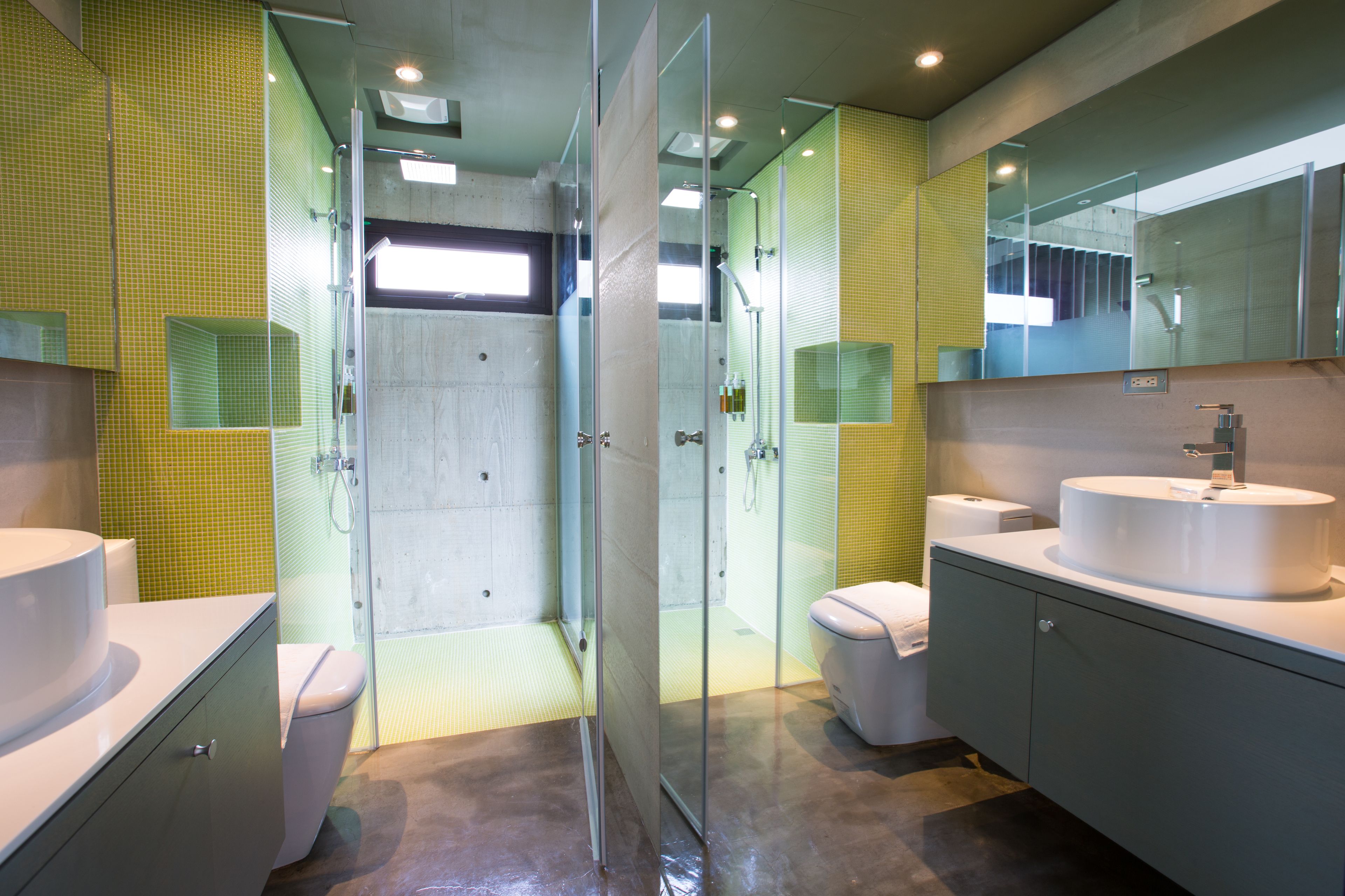 A modern bathroom with a glass-enclosed shower, two sinks, and a large mirror.