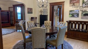A dining area with a round table, six chairs, and a chandelier. There are two wooden benches and a fireplace. - Charming Hilltop Home with City View (Chippewa Falls)