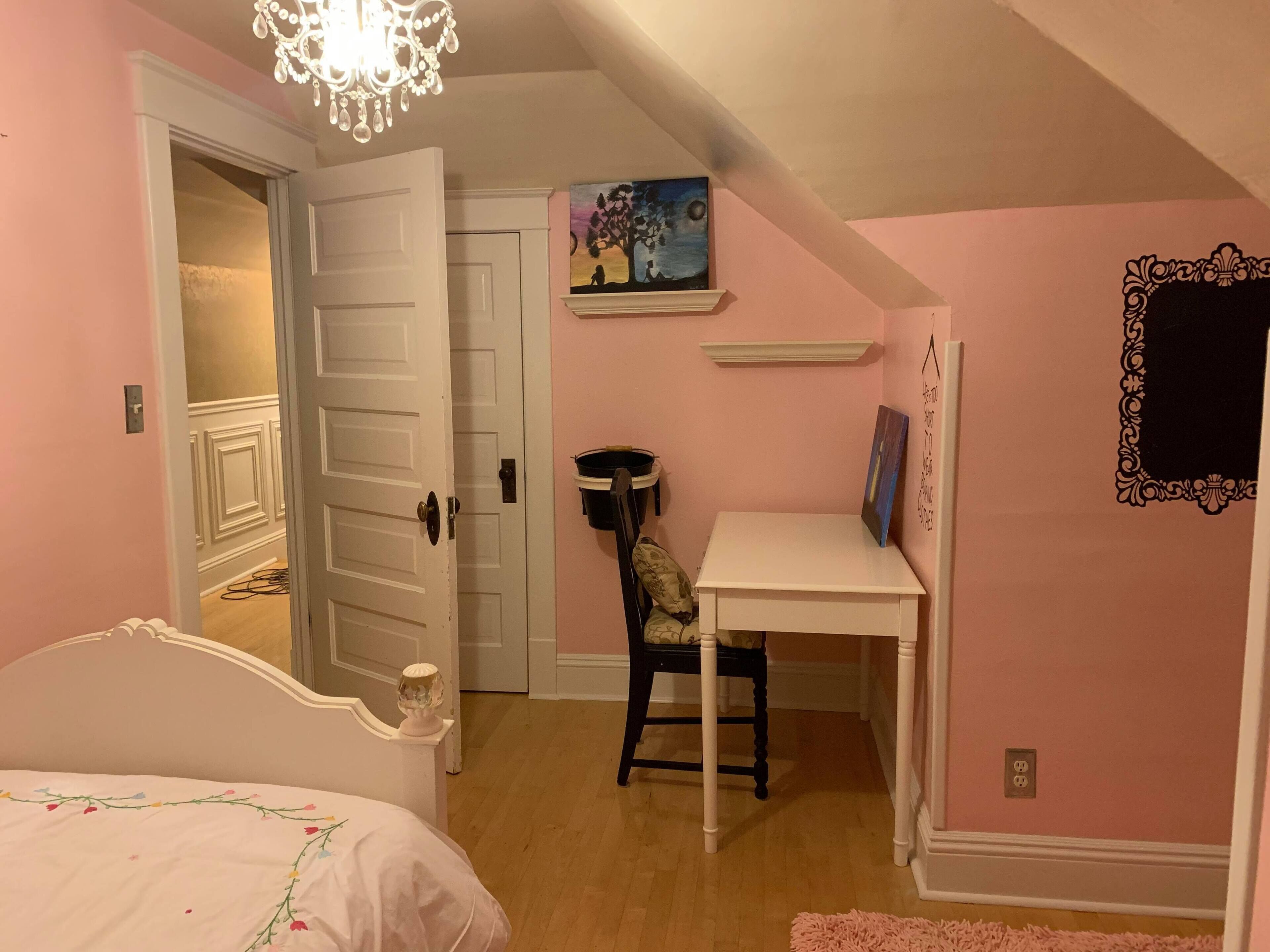 Un dormitorio con cama, escritorio y silla.