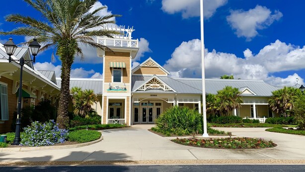 Ein Resort mit einem zentralen Gebäude mit der Aufschrift „Sea Breeze Recreation Center“, umgeben von gepflegten Gärten und Palmen.