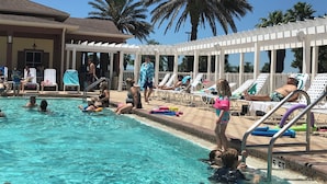 Ein Poolbereich mit Liegestühlen und Palmen.