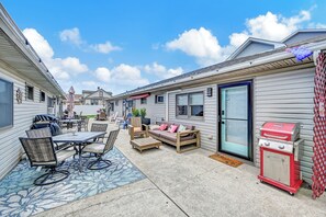 Une maison de style caravane dotée d’un patio aménagé avec des meubles d’extérieur, un barbecue et un petit jardin.