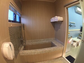 Une salle de bain avec une douche à l’italienne, un porte-serviettes et un sèche-mains.