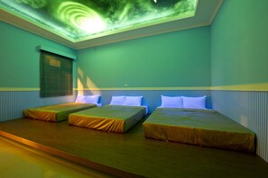 A room with three beds, a skylight, and a window with blinds. - Donggang Neptune Hall (Donggang)