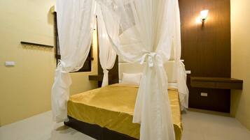 Una habitación con cama, mesita de noche, lámpara de pared y espejo.