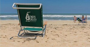 A beach chair with 'Ships Watch' branding on a sandy beach. - Kemme is 2 blocks to beach; Easy Walk to community pool, hot tub (Duck)