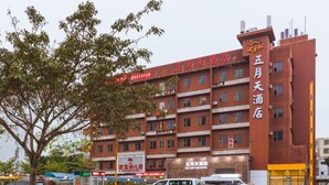 A multi-story hotel with a red facade and multiple balconies.