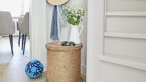 A hallway with a wicker basket, a hat, and a vase with flowers. - Villa Fortuna (Sellin)