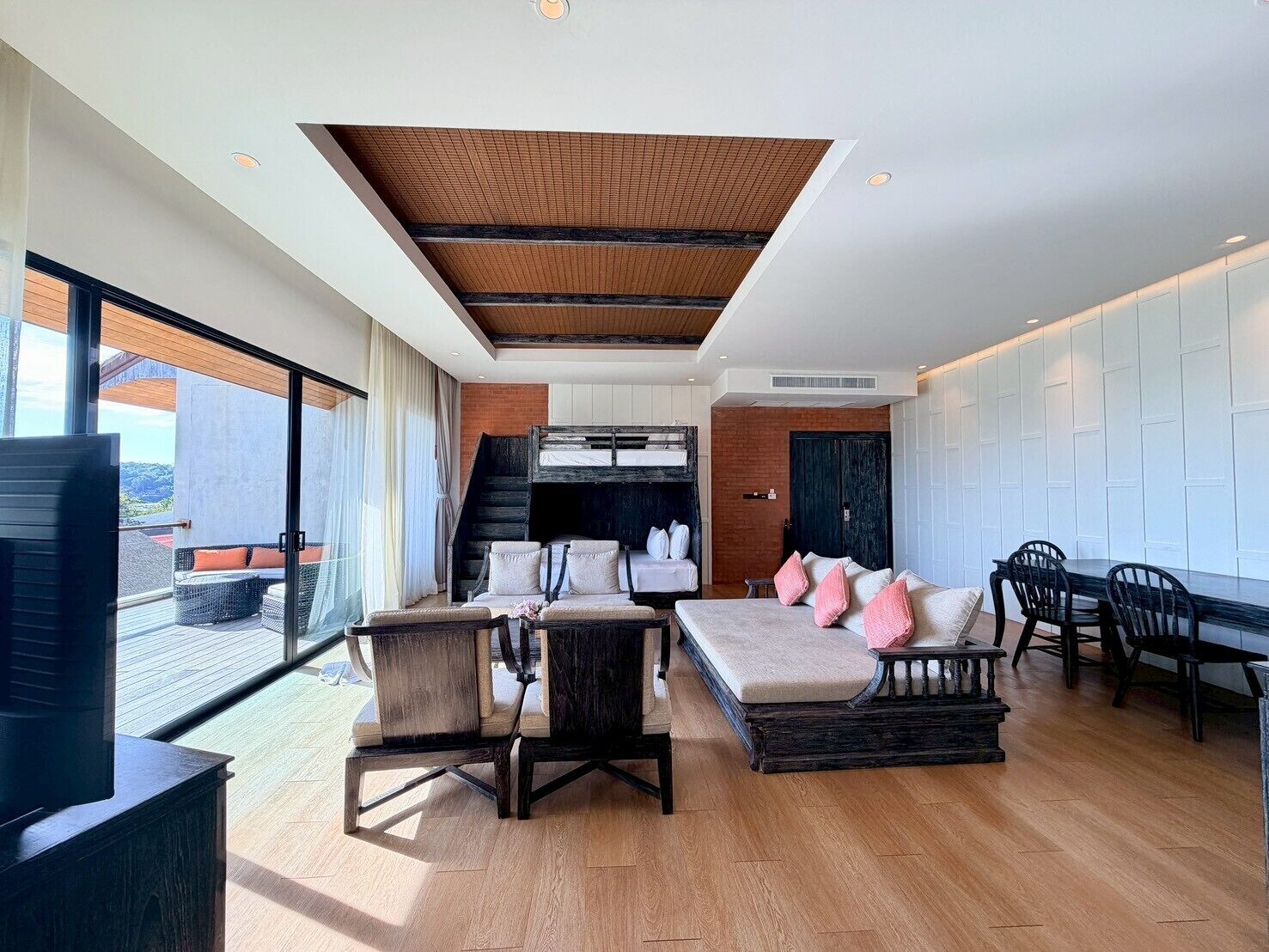 Un interior moderno con un área de estar tipo loft, una mesa de comedor y una cocina al fondo.