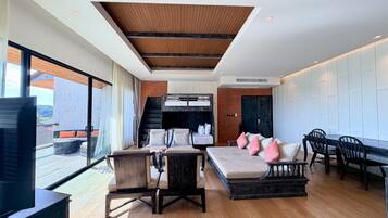 Un interior moderno con un área de estar tipo loft, una mesa de comedor y una cocina al fondo.