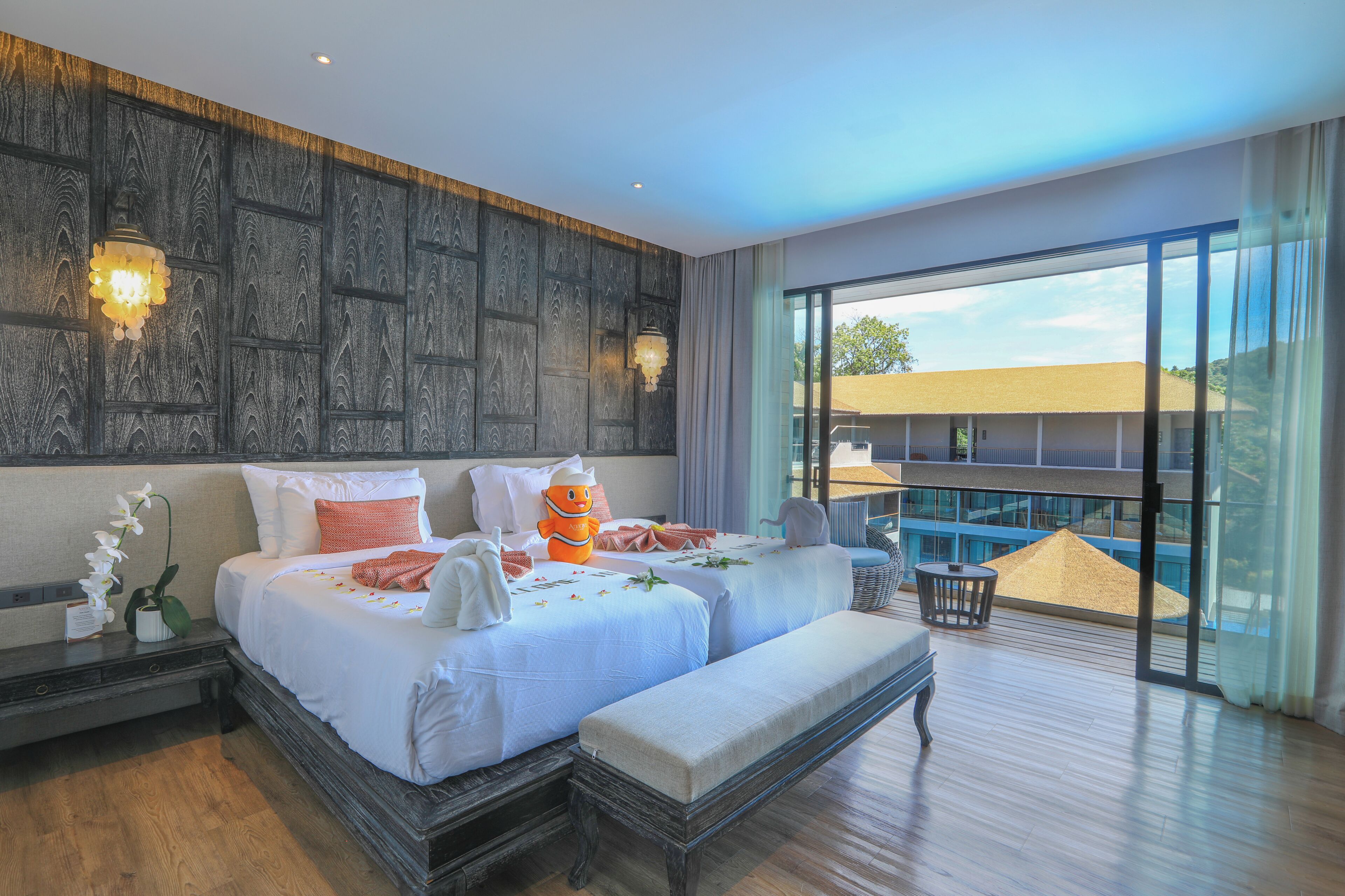 Une chambre d’hôtel avec deux lits, un balcon et une vue sur un immeuble.