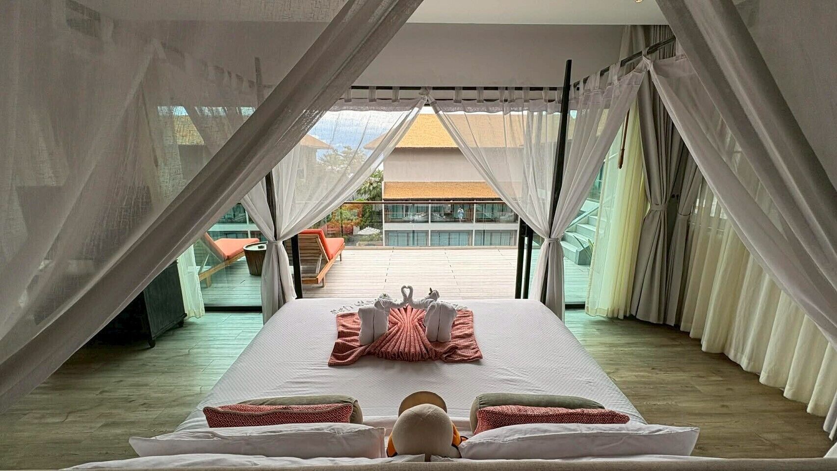 Un dormitorio con cama, cortinas y vistas al exterior.