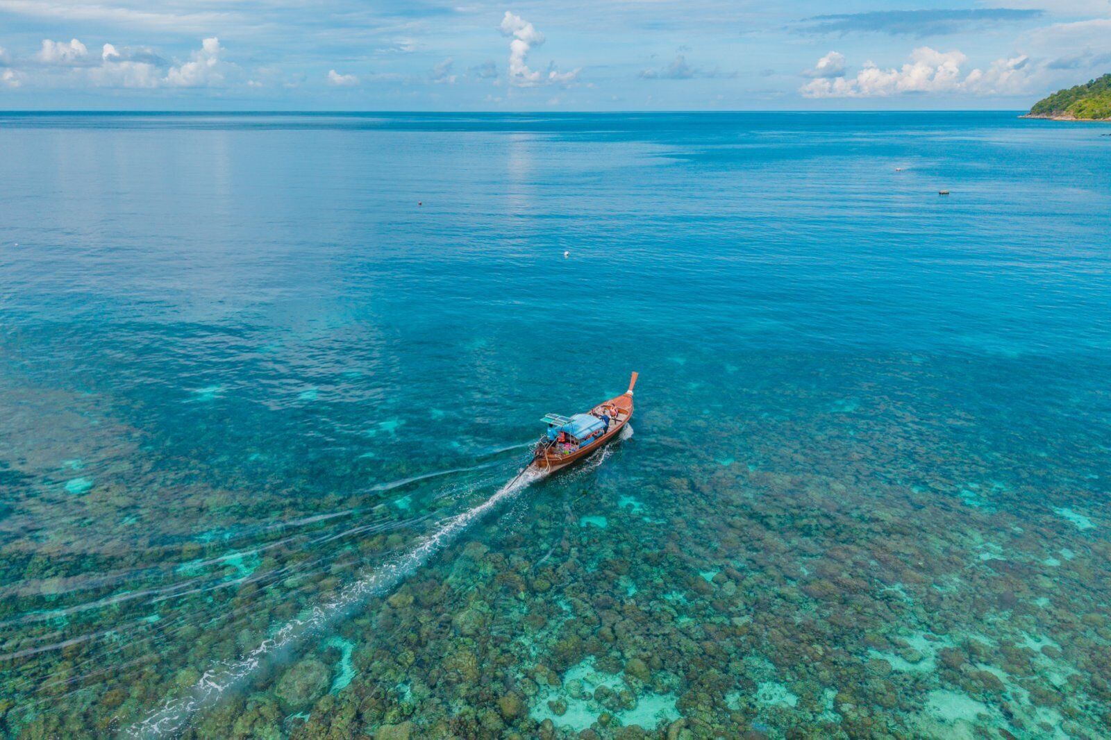 Ein Boot auf klarem, blauem Wasser mit steinigen Unterwasserfelsen.