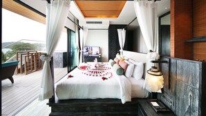 Un dormitorio moderno con una cama grande, techo de madera y balcón con vistas.