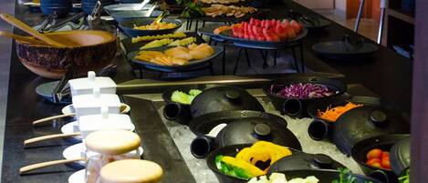 A buffet with various food items and utensils.