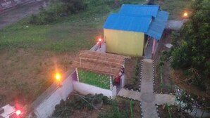 Et boligområde med et hus, blåt tag og en lille have med beplantning og en sti.