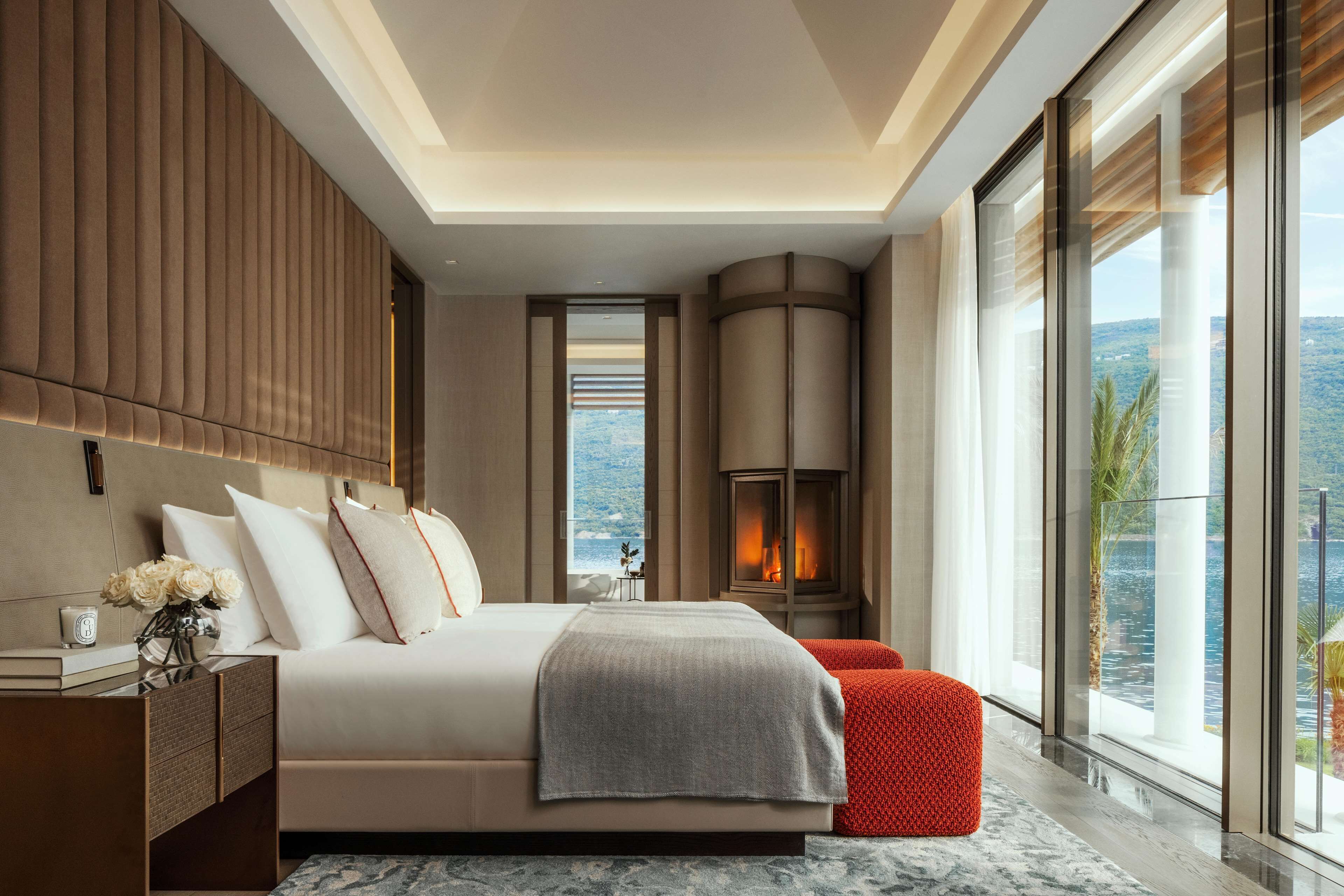 Un dormitorio moderno con una cama grande, una chimenea y vistas a la ciudad.
