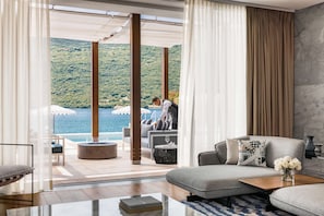 Una sala de estar moderna con un sofá, una mesa de centro y vista al mar.