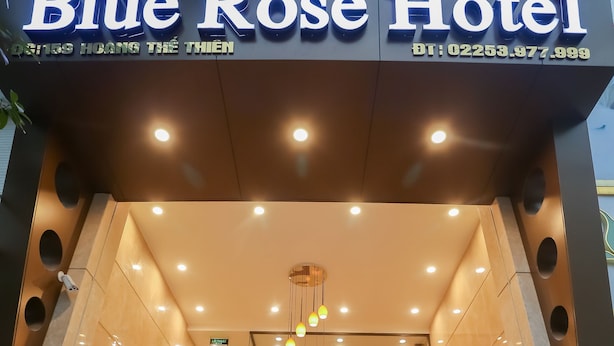The exterior of Blue Rose Hotel with a modern design, a staircase, and a Christmas tree.