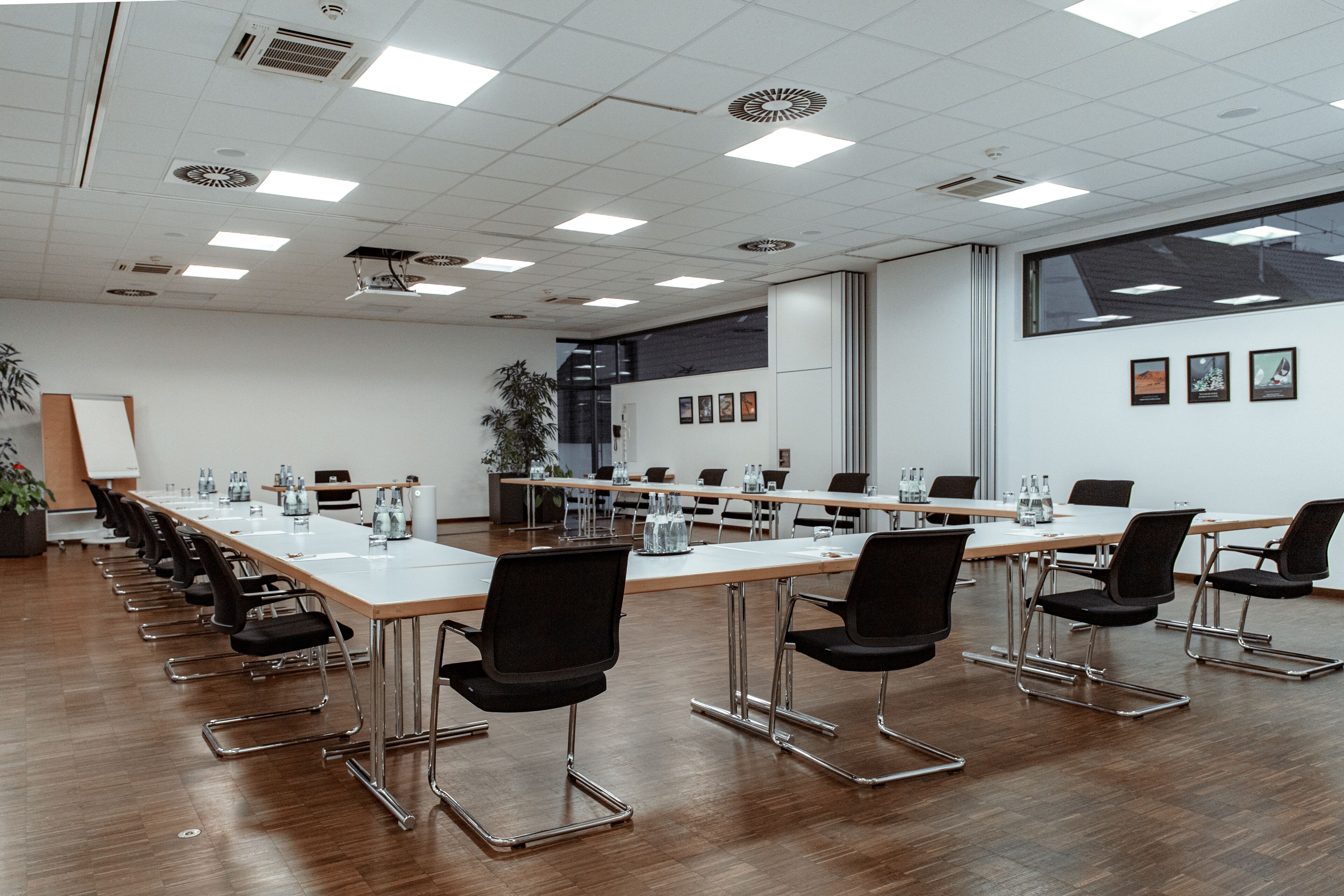 A conference room with a long table, black chairs, and a whiteboard.