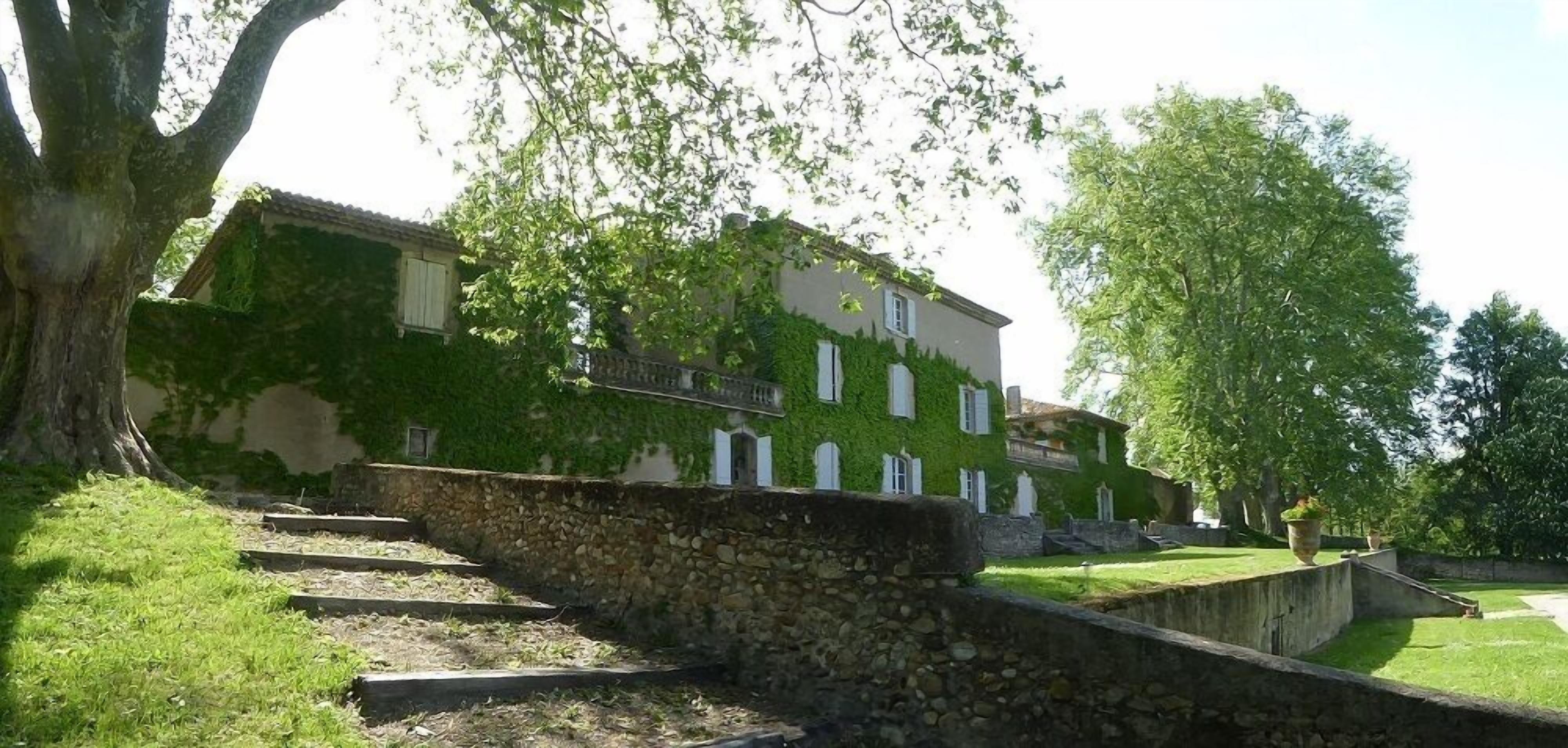 A stone staircase leading up to a building with a green ivy-covered facade.
