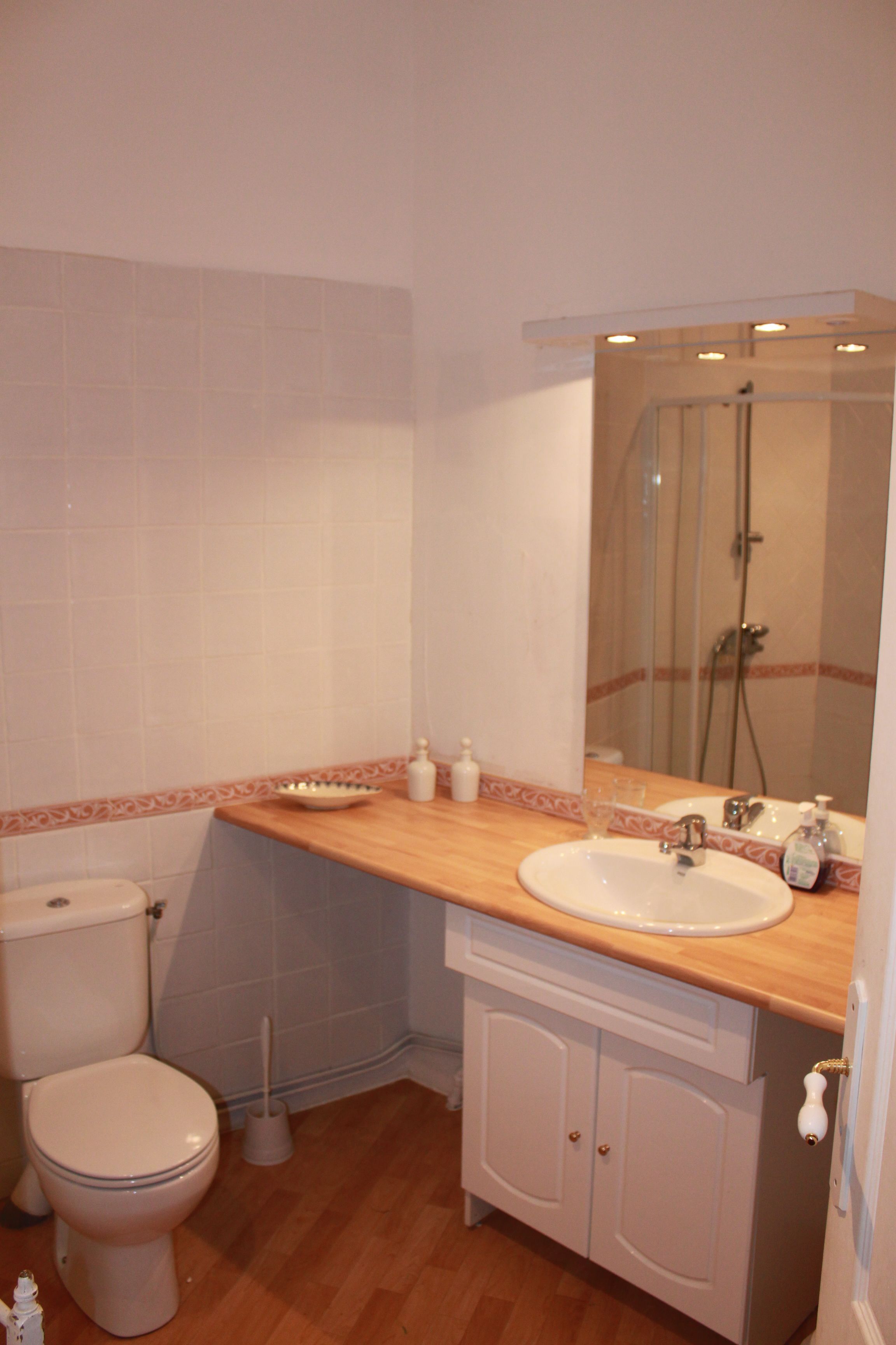 A bathroom with a toilet, sink, and shower.