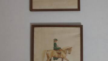 Zwei gerahmte Gemälde, die eine Person beim Reiten auf einem Pferd zeigen.