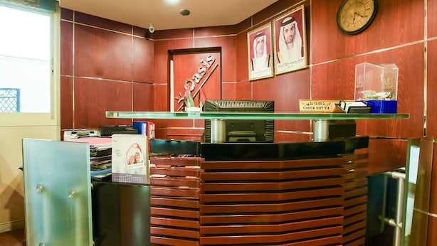 A reception area with a wooden reception desk, a clock, framed pictures, and a glass display case.