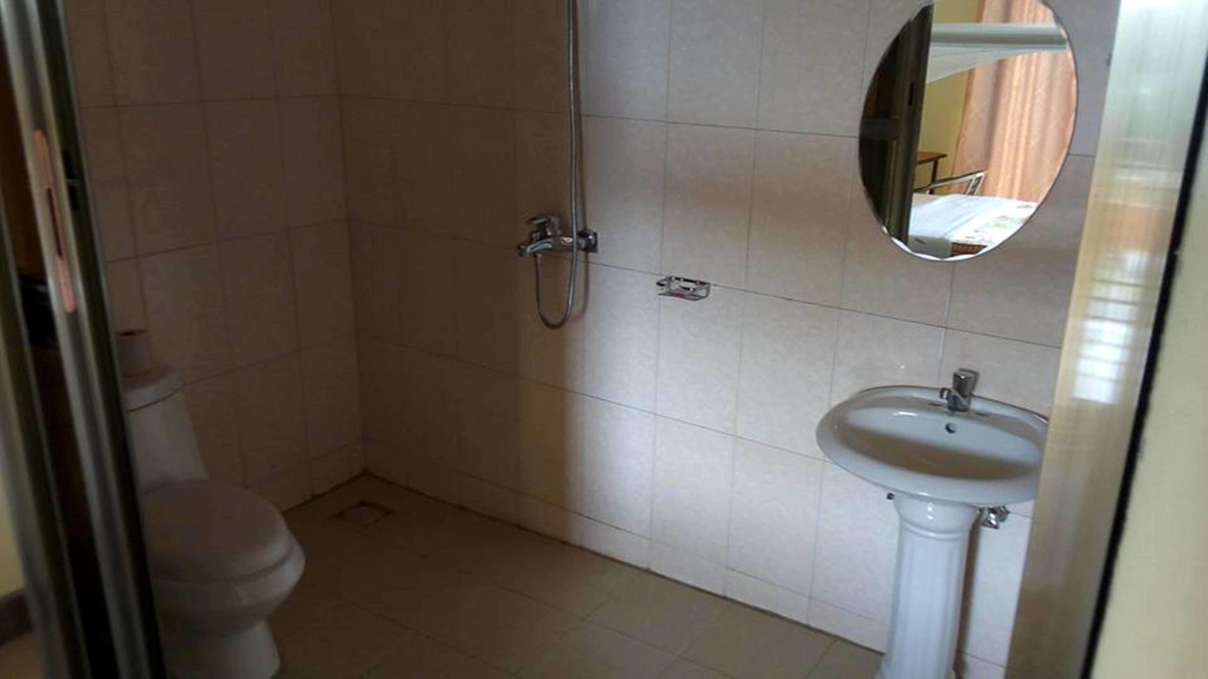 Un baño con inodoro, ducha y lavamanos.