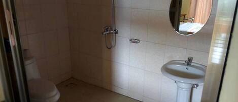 Un baño con inodoro, ducha y lavamanos.