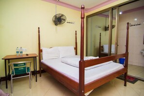 A four-poster bed with white linens, a wooden nightstand with a green chair, and a mirror reflecting the room. - Leosim Hotel (Pakwach)