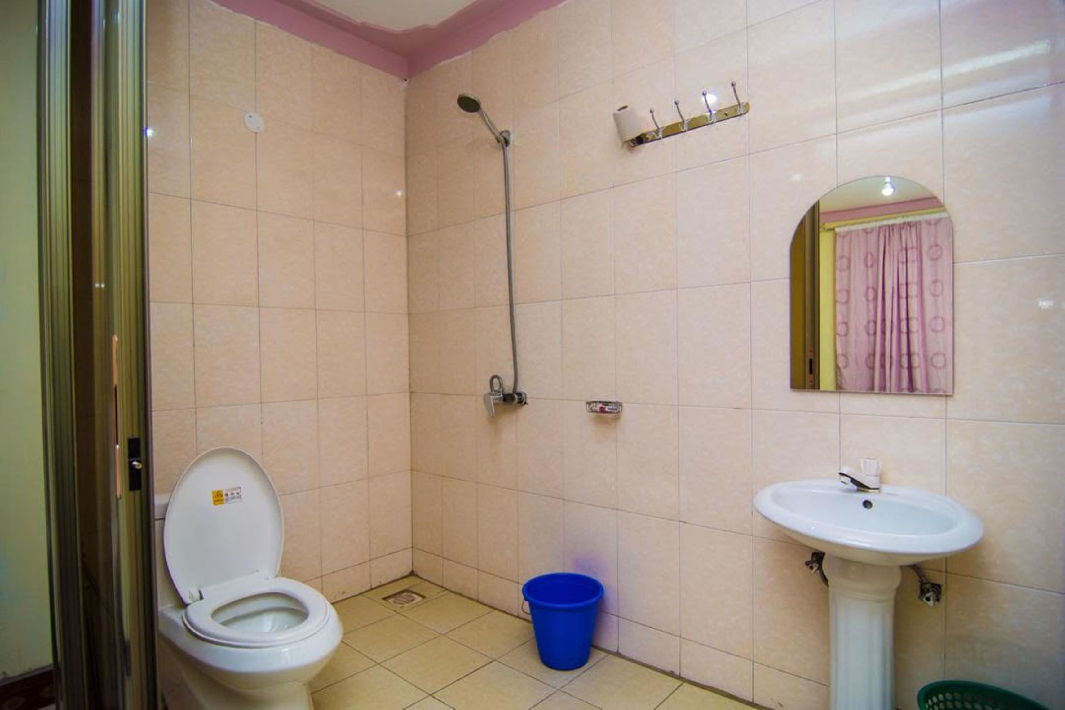 Un baño pequeño con inodoro, lavamanos, ducha y espejo.