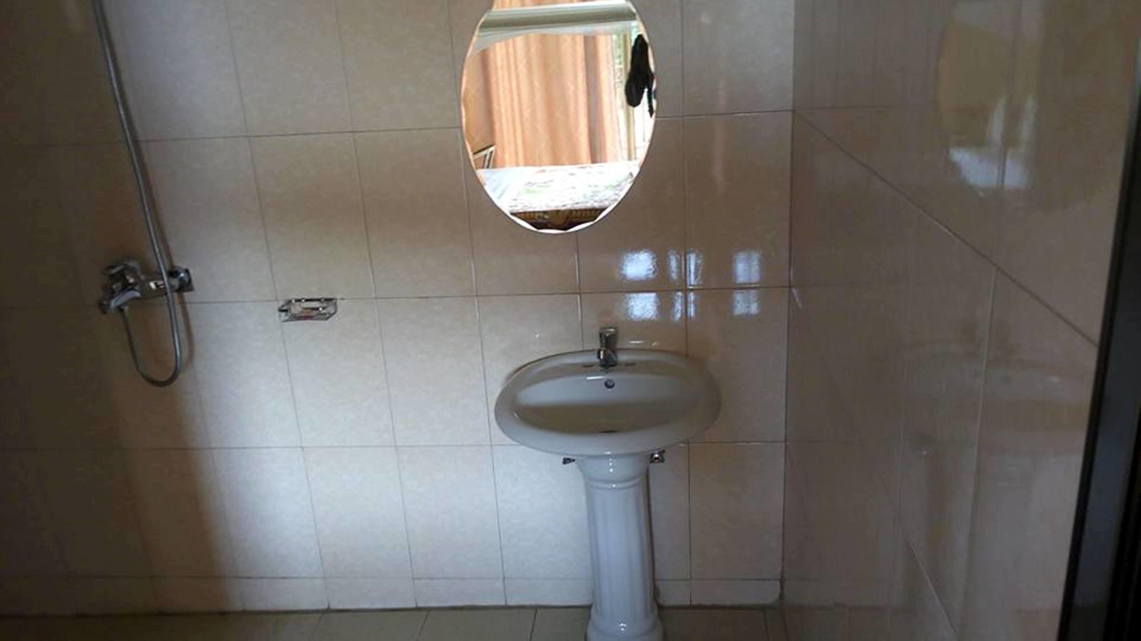 A bathroom with a pedestal sink and a shower.